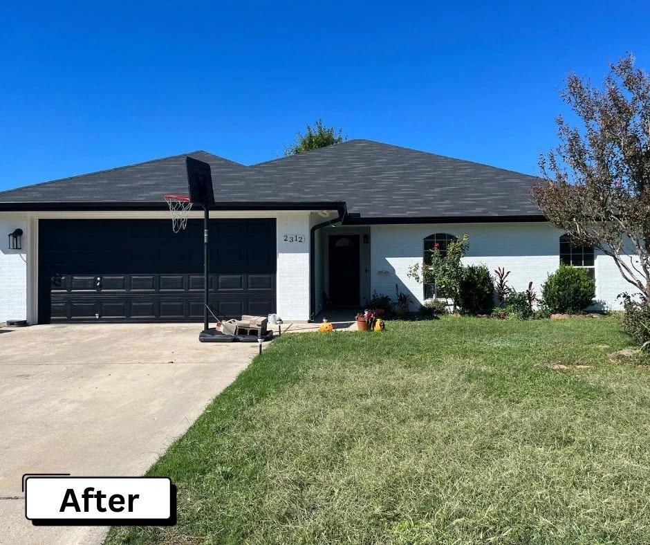 Exterior renovation in Temple, TX: painted white brick, charcoal roof, and black garage door by Slickrock Development